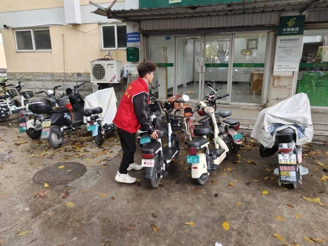 图2为党员志愿者停放电动车2.jpeg